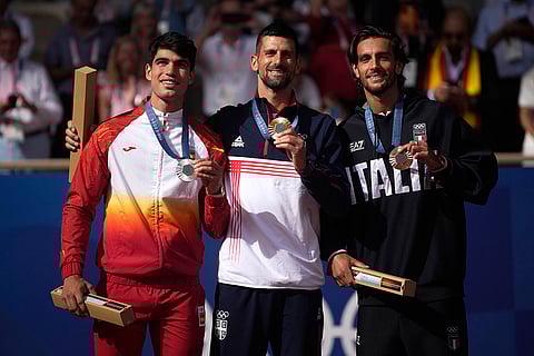 Gold medalist Novak Djokovic, center, silver medalist Carlos Alcaraz, left, and bronze medalist Lorenzo Musetti